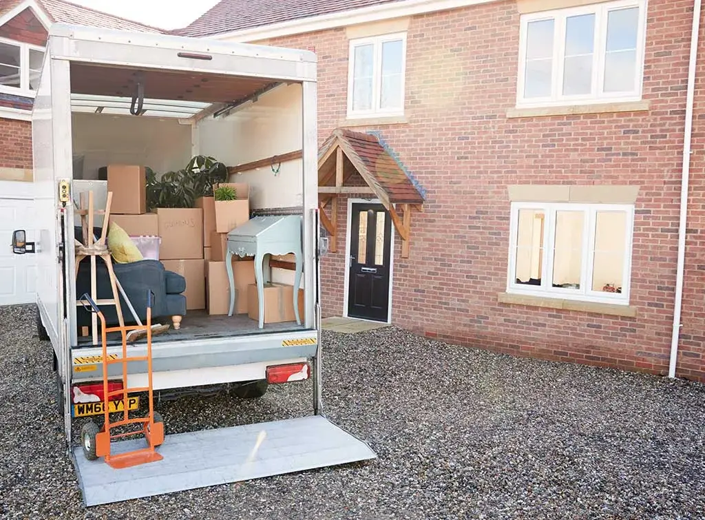 Furniture and boxes arranged beside a clearance van