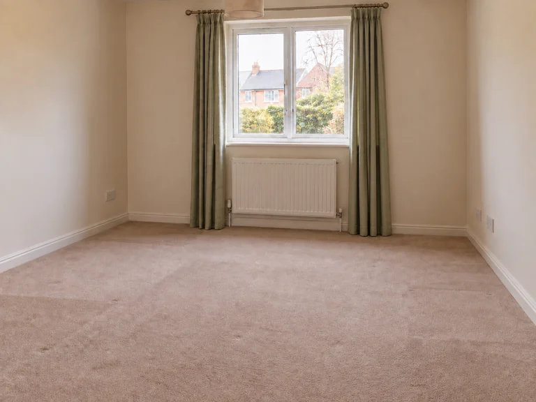 Illustrative view of the same room cleared of furniture, with carpet and curtains remaining